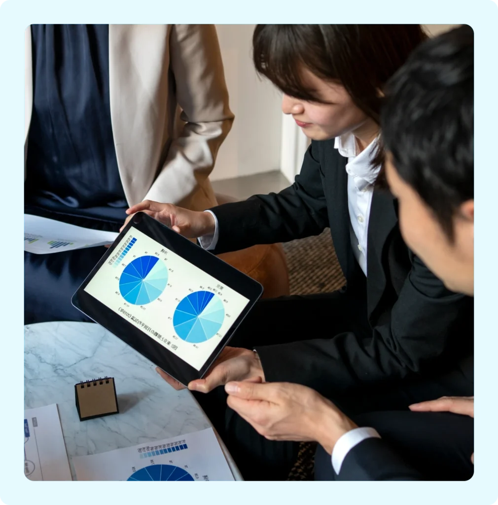 A girl is showing some graphs on her iPad to her colleagues